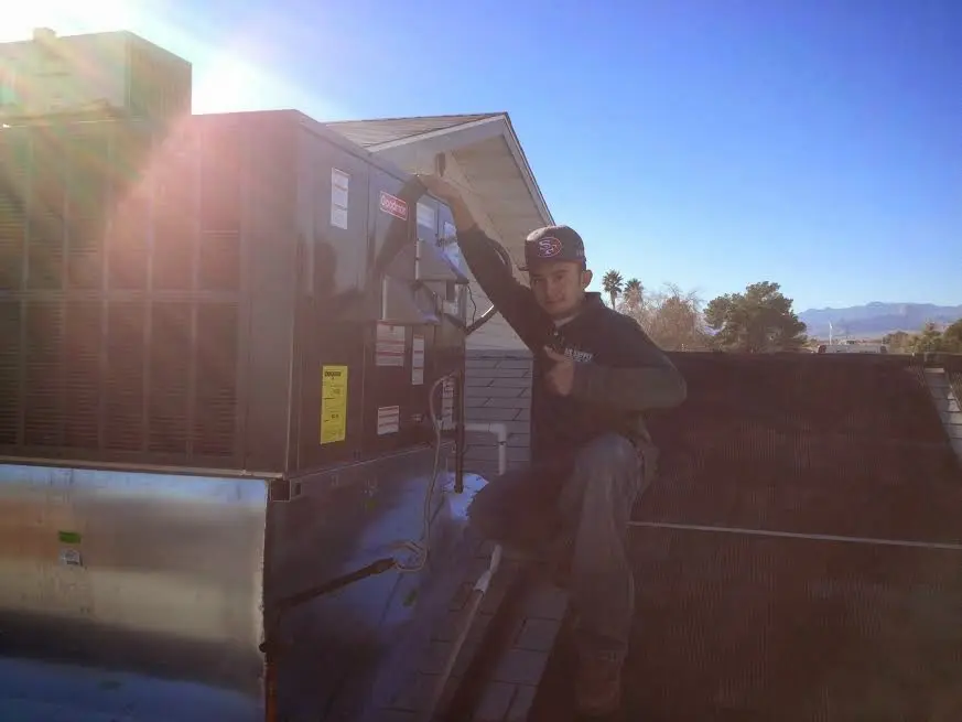 HVAC technician performing Air Duct Cleaning on a rooftop unit in Oakdale